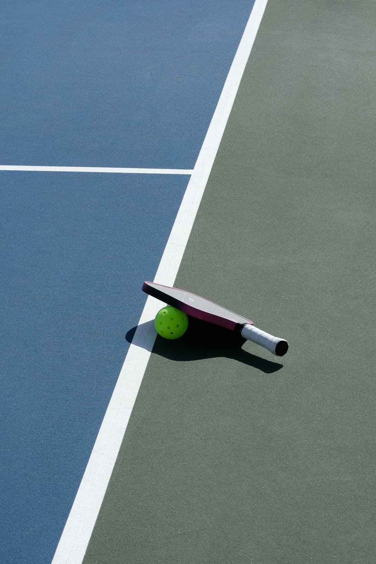 Pickleball paddle and ball on an outdoor court